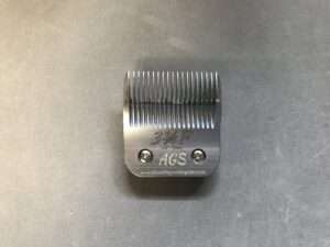 Metal clipper blade on gray background.