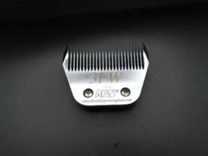 Silver grooming clipper attachment on black surface.