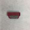 Red plastic flea comb on fabric surface.