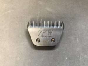 Metal hair clipper attachment on gray background.
