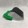 Green handled dough scraper on white surface.