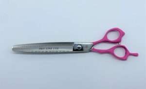 Pro-Line scissors with pink handles on white background.