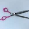 Pink-handled thinning shears on white background.