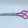 Pink-handled hair cutting scissors.