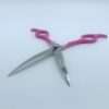Pink-handled curved grooming scissors on white background.
