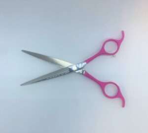 Pink-handled scissors on white background