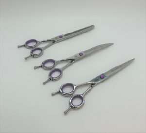 Three professional hairdressing scissors on white background.