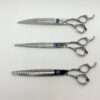 Three professional hairdressing scissors on white background.