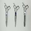 Three professional hairdressing scissors on white background.