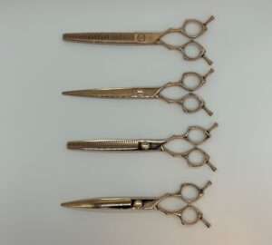 Professional hairdressing scissors on a white background.