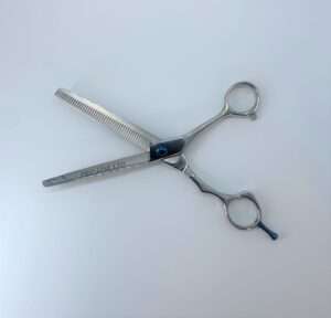 Professional hair thinning scissors on white background