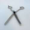 Stainless steel barber thinning scissors on white background.