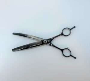 Professional hair thinning scissors on white background.