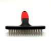 Red and black pet grooming brush on white background.