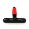 Red and black pet grooming brush on white background.