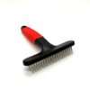 Red and black pet grooming brush on white background.