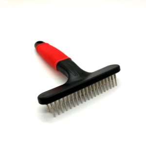 Red and black pet grooming brush on white background.