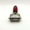 Red handle manual pet dematting tool on white background.