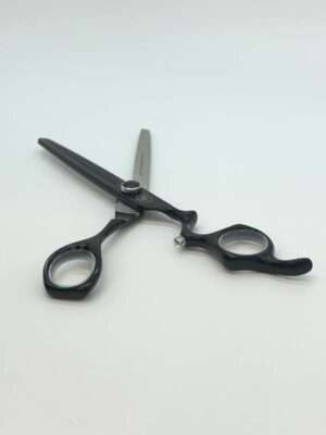 Black professional hairdressing scissors on white background.