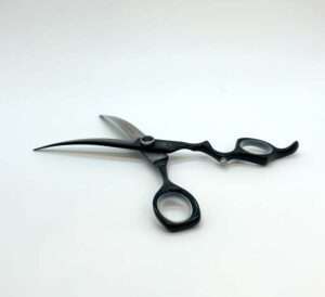 Professional black hairdressing scissors on white background.
