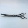 Curved black grooming shears on white background.