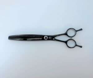 Black hair thinning scissors on white background.