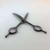 Professional black hairdressing scissors on white background.