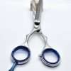 Stainless steel hair thinning scissors on table.