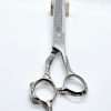 Decorative hair thinning scissors on wooden block.