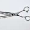 Professional hair thinning scissors on white background.