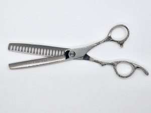 Professional hair thinning scissors on white background.