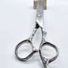 Decorative silver scissors on white background