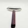 Metal grooming comb with striped handle.