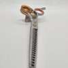 Hair thinning scissors with orange handles on stand.