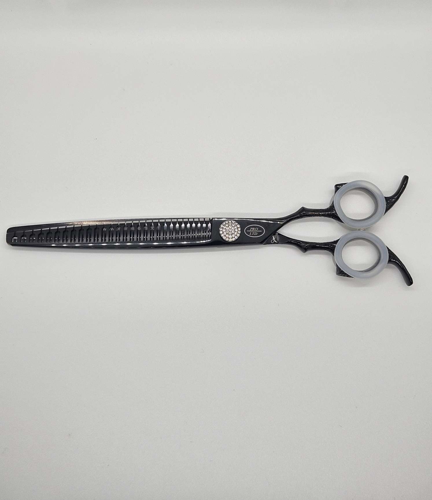 Black professional hair thinning scissors on white background.